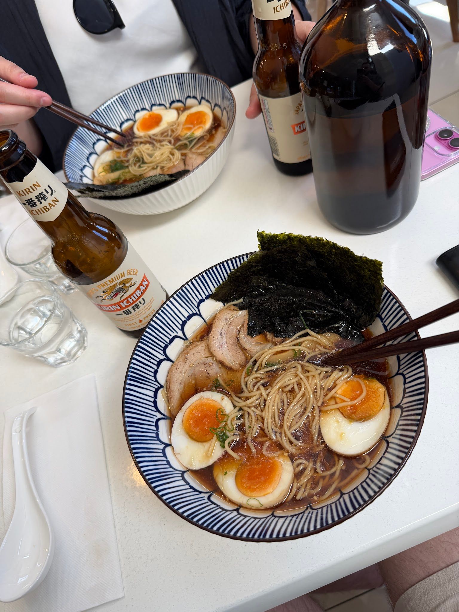 Ramen being eaten with chopsticks alongside Kirin beer at SAYANG